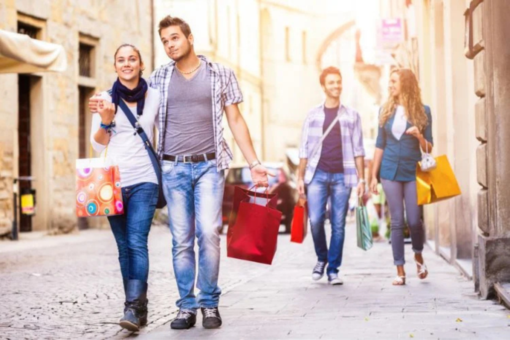 Smiling couples walking down a charming street with shopping bags, enjoying a day out.