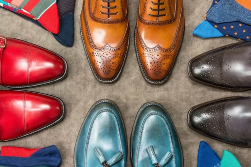 Top view of colorful leather shoes in various styles arranged in a circle with matching socks.