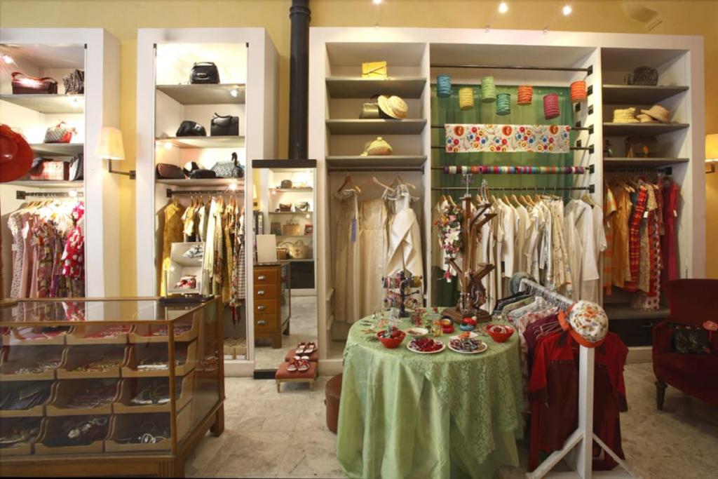 Vintage boutique interior with colorful clothing, accessories, and decor neatly displayed.